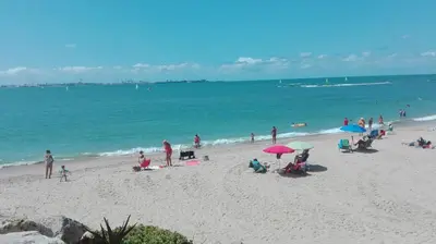 a group of people sitting on a beach with umbrellas at Loft El pez blanco in El Puerto de Santa María