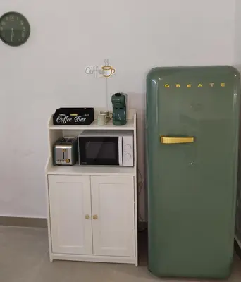 a small kitchen with a microwave and a refrigerator at La corrala de la calle Sol in Jerez de la Frontera