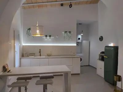 a kitchen with white cabinets and a green refrigerator at La corrala de la calle Sol in Jerez de la Frontera