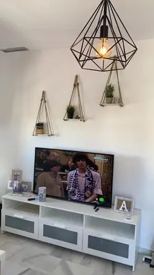 a flat screen tv sitting on top of a entertainment center at Acogedor apartamento en Bahía Blanca, Cádiz a 3 min de la playa in Cádiz