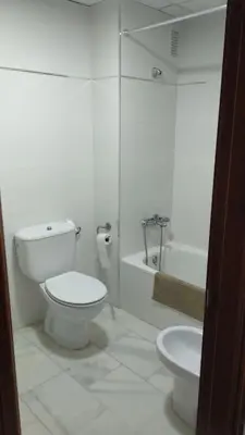 a white bathroom with a toilet and a bath tub at Acogedor apartamento en Bahía Blanca, Cádiz a 3 min de la playa in Cádiz