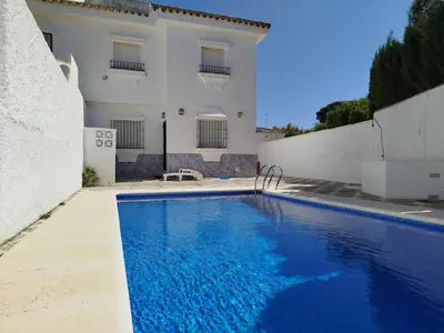 a villa with a swimming pool in front of a building at Villa Duplex 3 Bedrooms, 400 M to the beach, Pool in Novo Sancti Petri