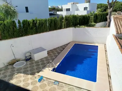 a blue swimming pool on the side of a building at Villa Duplex 3 Bedrooms, 400 M to the beach, Pool in Novo Sancti Petri