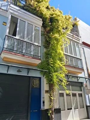 a building with a blue door and a plant at Tartaneros Playa con Parking in Sanlúcar de Barrameda