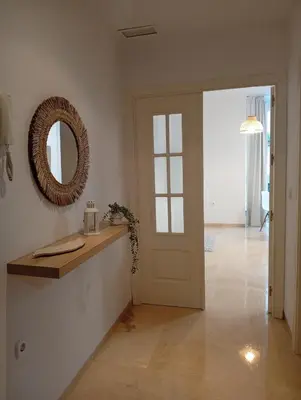 a hallway with a door and a mirror on the wall at Tartaneros Playa con Parking in Sanlúcar de Barrameda