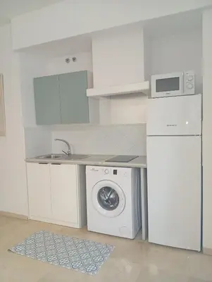 a white kitchen with a washing machine and a sink at Tartaneros Playa con Parking in Sanlúcar de Barrameda