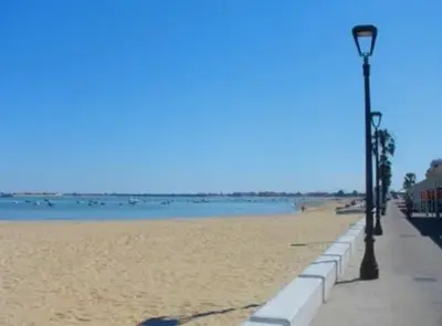 a street light on the beach near the water at Tartaneros Playa con Parking in Sanlúcar de Barrameda