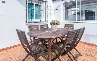 a wooden table and chairs on a patio at Stunning Home In Chiclana De La Fronter in Novo Sancti Petri
