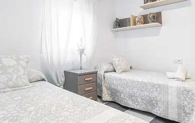 a bedroom with two beds and a dresser and a window at Stunning Home In Chiclana De La Fronter in Novo Sancti Petri