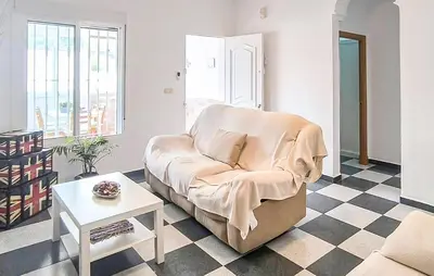 a living room with a chair and a table at Stunning Home In Chiclana De La Fronter in Novo Sancti Petri