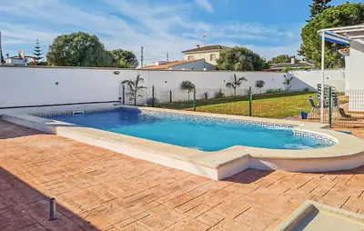 a swimming pool in the backyard of a house at Stunning Home In Chiclana De La Fronter in Novo Sancti Petri
