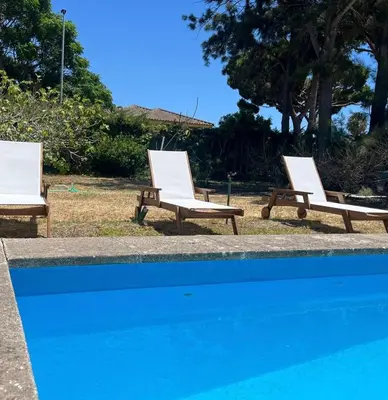 three lounge chairs sitting next to a swimming pool at a casiña cottage in Chiclana in Chiclana de la Frontera