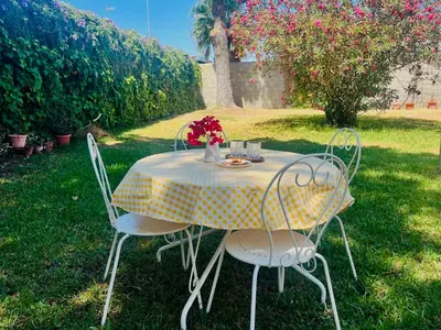 a table with two chairs and a table with flowers on it at a casiña cottage in Chiclana in Chiclana de la Frontera