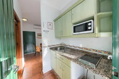 a bedroom with a yellow bed and a window at Bungalows - Conil Playa in Conil de la Frontera