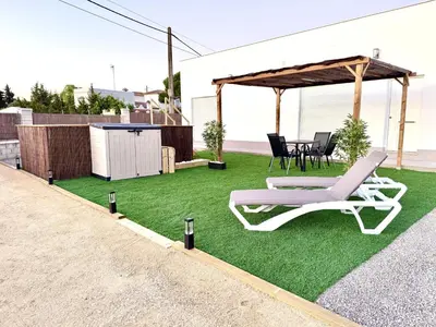 a lawn with a chair and a gazebo at Casa Abuelo Pedro in Conil de la Frontera