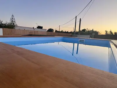 a swimming pool with a reflection of the sky at Casa Abuelo Pedro in Conil de la Frontera