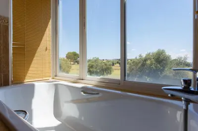 a bath tub in a bathroom with two windows at Villa 237 by Villamya in Arcos de la Frontera