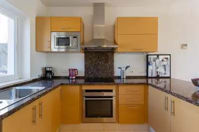 a kitchen with wooden cabinets and a sink and a stove at Villa 237 by Villamya in Arcos de la Frontera