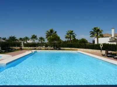 a large swimming pool with palm trees in the background at Villa 237 by Villamya in Arcos de la Frontera