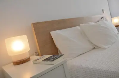 a bed with a white pillow and a lamp on a night stand at Villa Puntalejo por Living Cadiz in Conil de la Frontera
