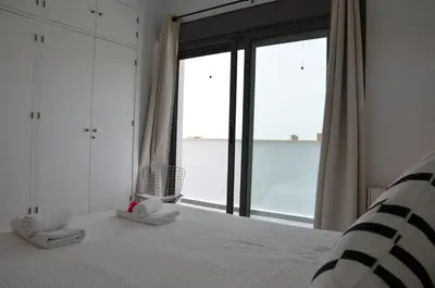 a bedroom with a bed and a large window at Villa Puntalejo por Living Cadiz in Conil de la Frontera