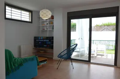 a living room with a couch and a glass door at Villa Puntalejo por Living Cadiz in Conil de la Frontera