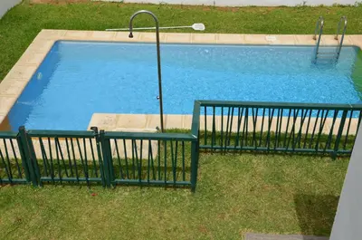 a swimming pool with a green fence around it at Villa Puntalejo por Living Cadiz in Conil de la Frontera