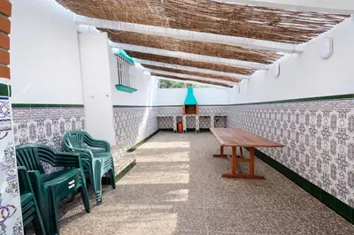 a room with green chairs and a wooden table at Chalet Amanecer Chiclana in Novo Sancti Petri