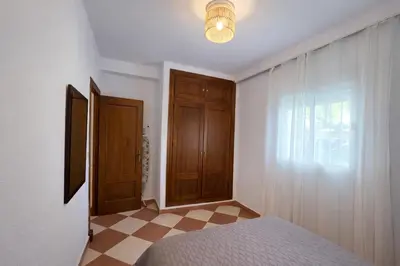 a bedroom with a bed and a window and a door at Chalet Amanecer Chiclana in Novo Sancti Petri