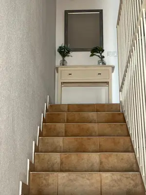 a staircase with a mirror and a television on a wall at La Balconera Apartamento junto a la playa in Novo Sancti Petri
