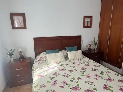 a bedroom with a bed with a floral bedspread at La Balconera Apartamento junto a la playa in Novo Sancti Petri