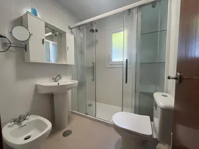 a bathroom with a shower and a toilet and a sink at La Balconera Apartamento junto a la playa in Novo Sancti Petri