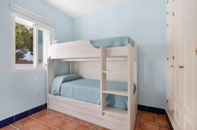 a bunk bed with a ladder in a room at Townhouse in La Loma de Sancti Petri , 3 Bedrooms, Pool, Pedal Tennis in Novo Sancti Petri