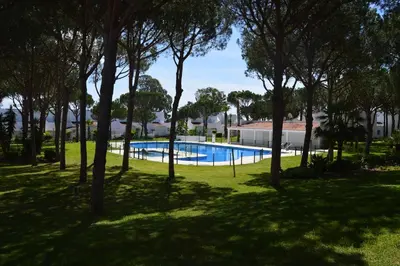 a swimming pool in a park with trees at Townhouse in La Loma de Sancti Petri , 3 Bedrooms, Pool, Pedal Tennis in Novo Sancti Petri