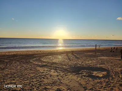 a sunset on a beach with the ocean at Beachside Duplex Chalet -800 m to La Barrosa Beach in Novo Sancti Petri