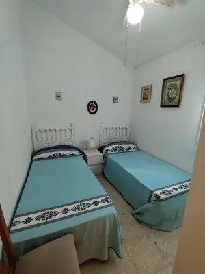 a bedroom with two beds and a chair at Beachside Duplex Chalet -800 m to La Barrosa Beach in Novo Sancti Petri
