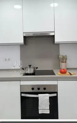 a kitchen with a stove with a pot on it at Apartamento Marea en primera línea de playa en La Barrosa con vistas al mar in Novo Sancti Petri