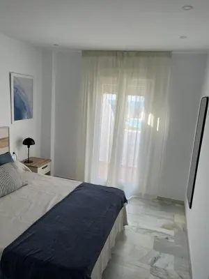 a bedroom with a bed and a large window at Apartamento Marea en primera línea de playa en La Barrosa con vistas al mar in Novo Sancti Petri