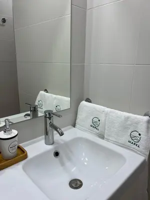 a white bathroom sink with a mirror and towels at Apartamento Marea en primera línea de playa en La Barrosa con vistas al mar in Novo Sancti Petri
