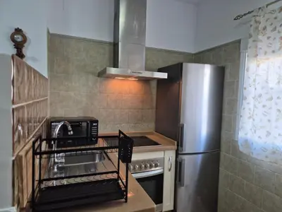 a small kitchen with a stainless steel refrigerator at Apartamento Bahia de Cadiz in Puerto Real