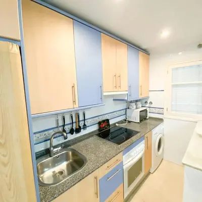 a kitchen with blue cabinets and a sink at Bulerías de Cádiz by Gades Gestión in Cádiz