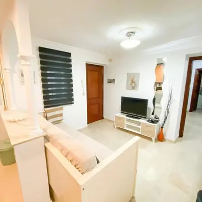 a living room with a couch and a television at Bulerías de Cádiz by Gades Gestión in Cádiz