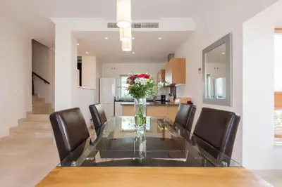 a dining room table with chairs and a vase of flowers at Villa 231 by Villamya in Arcos de la Frontera