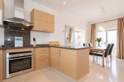 a kitchen with wooden cabinets and a dining room at Villa 231 by Villamya in Arcos de la Frontera