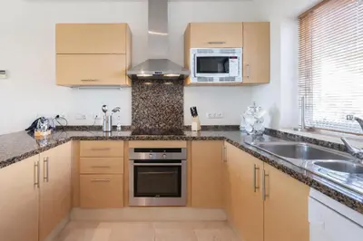 a kitchen with wooden cabinets and a sink at Villa 231 by Villamya in Arcos de la Frontera