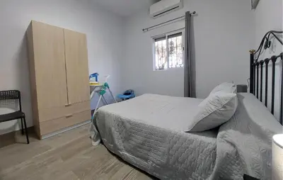a bedroom with a bed and a dresser and a window at Awesome Home In San José Del Valle in San Jose del Valle