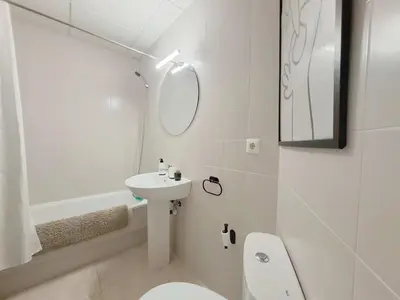 a white bathroom with a sink and a toilet at Ático luminoso con terraza de 28 m con plaza garaje a 9mn del centro in Sanlúcar de Barrameda