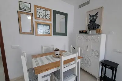 a dining room with a table and a table and chairs at Ático luminoso con terraza de 28 m con plaza garaje a 9mn del centro in Sanlúcar de Barrameda