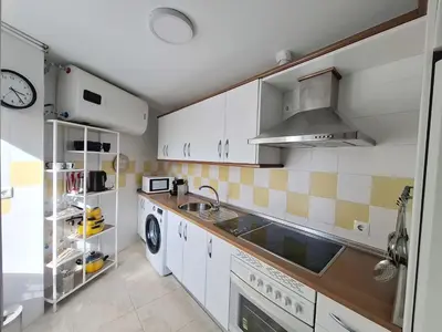a kitchen with white cabinets and a sink at Ático luminoso con terraza de 28 m con plaza garaje a 9mn del centro in Sanlúcar de Barrameda