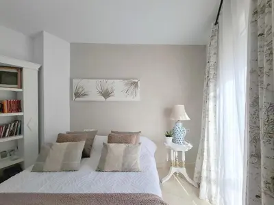 a white bedroom with a bed and a window at Ático luminoso con terraza de 28 m con plaza garaje a 9mn del centro in Sanlúcar de Barrameda